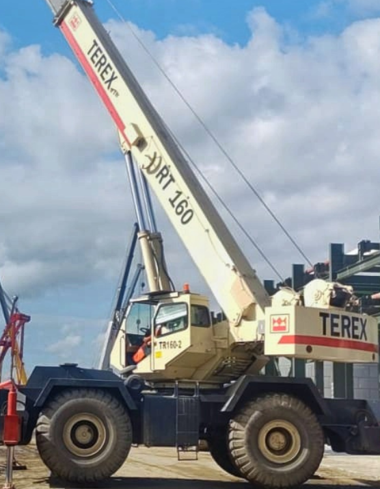 Grúa todoterreno Terex RT 160 levantando estructuras en un sitio de construcción.